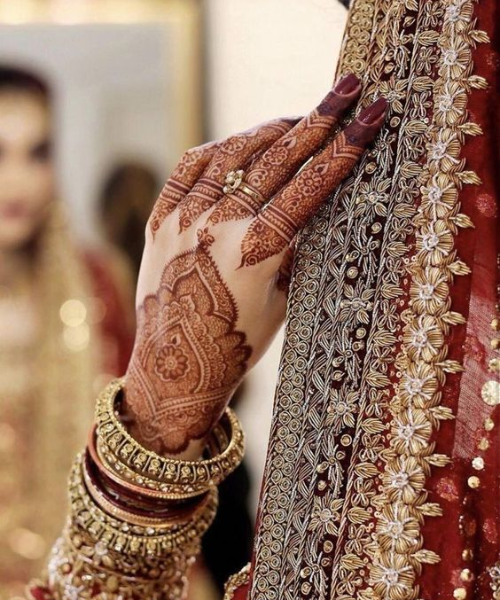 Shot of her hand with mehndi and her dupatta