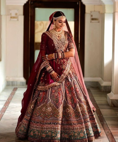 Maroon lehenga with intricate multicolor embroidery and traditional motifs