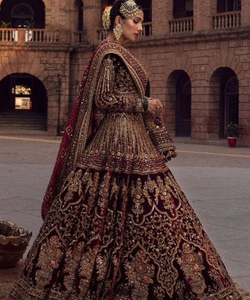 Deep maroon lehenga with dense, intricate gold embroidery