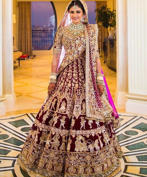 Maroon lehenga with gold temple motifs, richly detailed