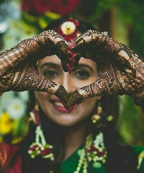 Making a heart while showing mehndi