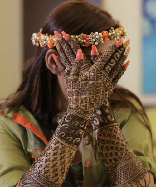 Bride covering her face while showing design