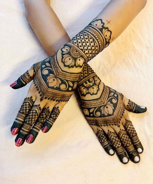 Bold mehndi with geometric patterns, floral motifs, and shaded tips