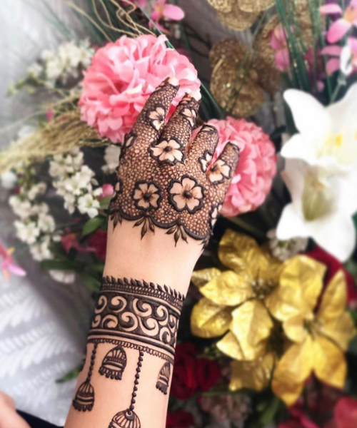 Floral mesh mehndi with bell motifs and bold wrist design