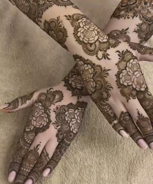 Dense floral mehndi with layered circular patterns.