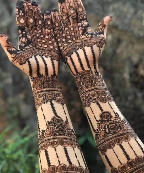 Elaborate bangle-style mehndi with floral bands and vertical lines